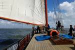 Guests on deck beneath the sails of the Avontuur