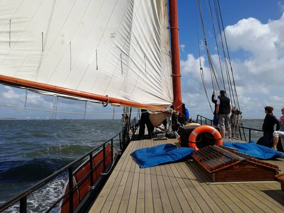 Guests on deck beneath the sails of the Avontuur