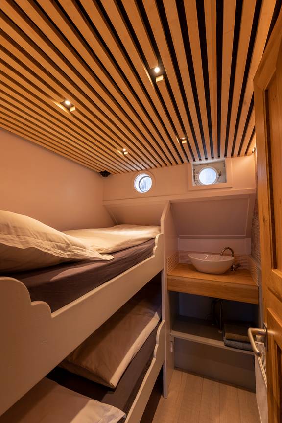 Cabin with a bunk bed and washbasin on the Avontuur
