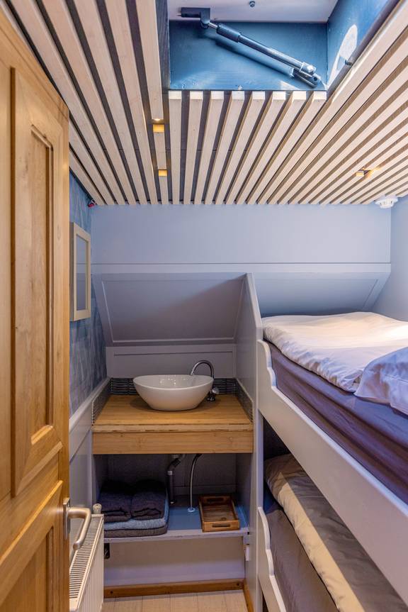 Cabin with a bunk bed, washbasin and skylight on the Avontuur