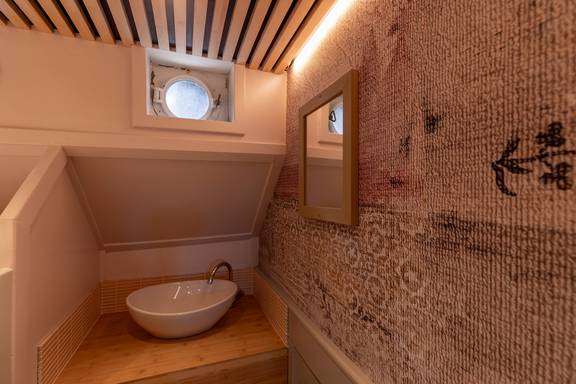 Washbasin beneath a porthole in a cabin of the Avontuur