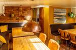 Seating area with a wooden table and copper pendant lamp in the Avontuur