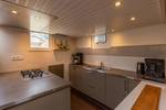 Galley with grey cabinets and a wooden worktop on the Avontuur