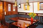 Saloon with a wooden table and benches on the tjalk Aagtje