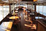 Wooden tables and chairs in the bright saloon of the Adeline