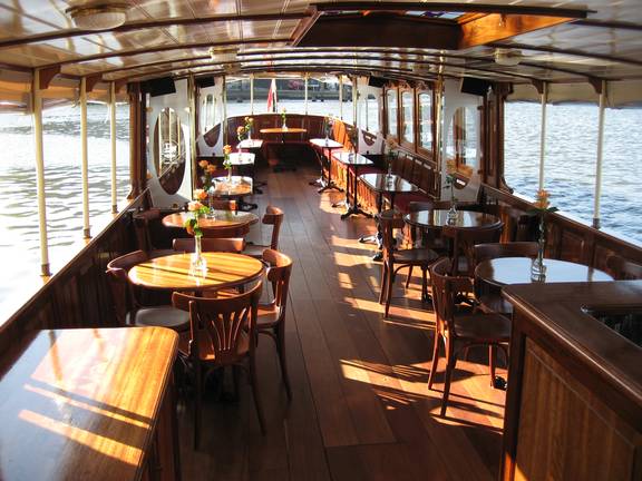 Wooden tables and chairs in the bright saloon of the Adeline