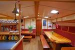 Saloon of the Albatros with wooden tables and red benches