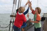 Children helping to hoist a sail together on the Albatros