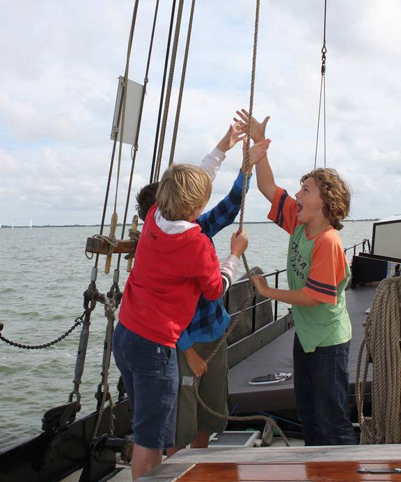 Children helping to hoist a sail together on the Albatros