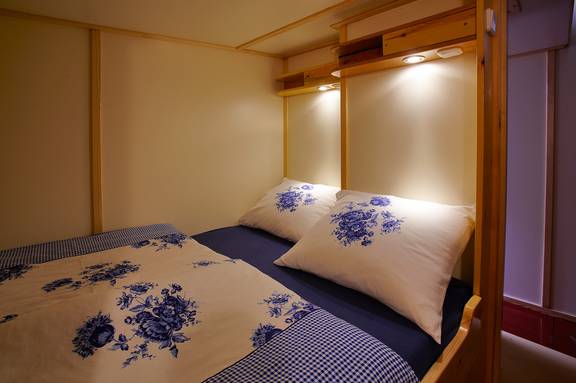 Enclosed double berth with blue-and-white bedding on the Albatros