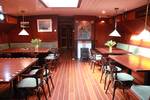 Saloon of the Aldebaran with wooden dining tables and red benches