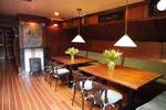 Saloon of the Aldebaran with wooden dining tables and red benches