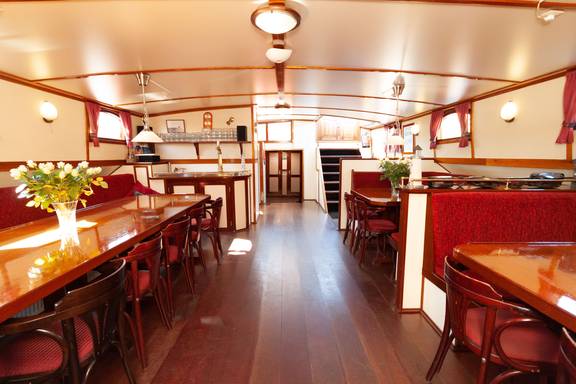 Saloon of the Allure with wooden dining tables and red benches
