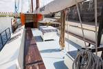 Deck seating area with wooden benches and a table on the Ambiance