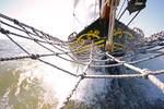 Bowsprit net and bow of the Ambiance with splashing water