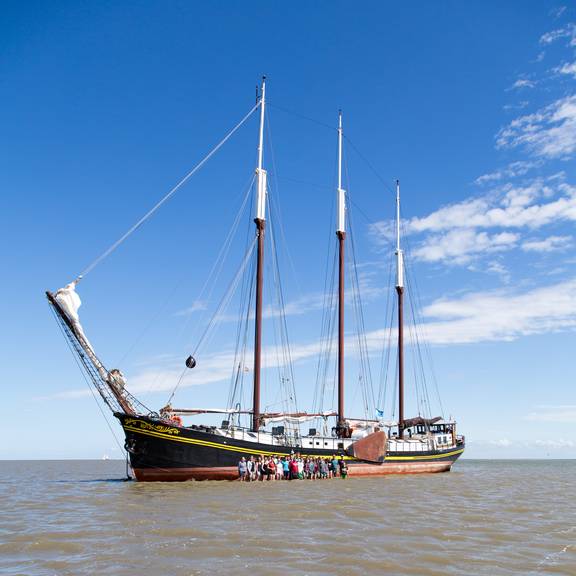 Group beside the Ambiance on the exposed tidal flats