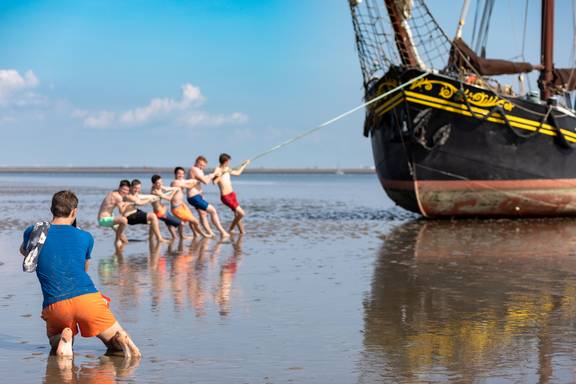 School pupils posing beside the Ambiance on the exposed tidal flats