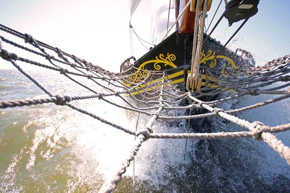 Bowsprit net and bow of the Ambiance with splashing water