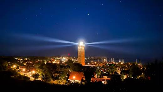 Illuminated lighthouse above Terschelling in the evening