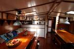 Saloon of the Anna Trijntje with wooden tables and blue bench seating