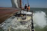 Guests at the bow of the Anna Trijntje with spray from the waves