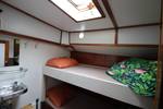 Bed and washbasin beneath a cabin skylight on the Anna Trijntje