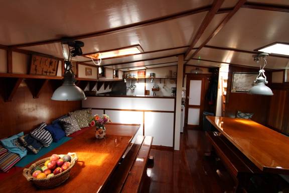 Saloon of the Anna Trijntje with wooden tables and blue bench seating
