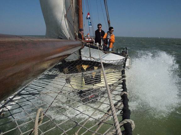 Guests at the bow of the Anna Trijntje with spray from the waves