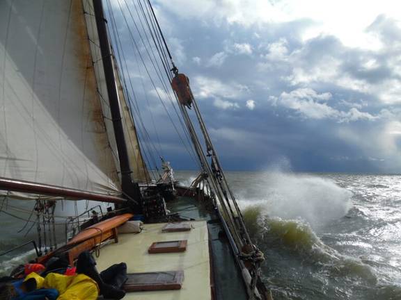 Anna Trijntje sailing through the waves beneath a cloudy sky