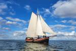 Clipper Anna under white sails beneath a blue sky