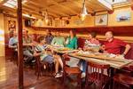 Guests at a table in the wood-panelled saloon of the clipper Anna