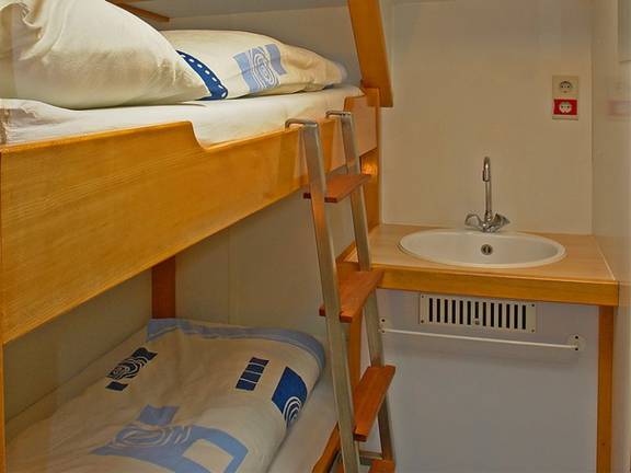 Wooden bunk bed and washbasin in a cabin of the Avanti