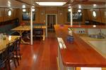 Saloon of the Avanti with long wooden dining tables