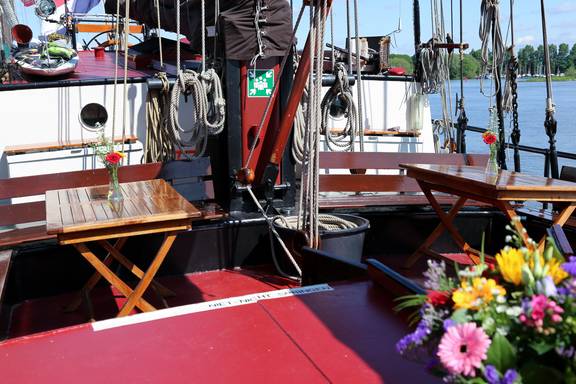 Deck seating area with wooden tables and flowers on the Avondrood