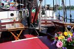 Deck seating area with wooden tables and flowers on the Avondrood