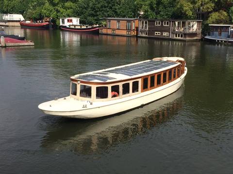 Saloon boat Belle van Zuylen cruising along a city canal