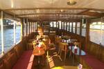 Wooden tables and chairs in the saloon of the Belle van Zuylen