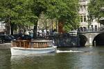 Saloon boat Belle van Zuylen beside a bridge in Amsterdam