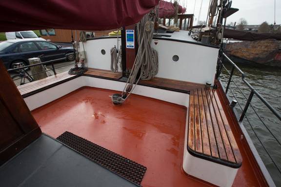 Wooden benches around the red deck seating area of the Boekanier
