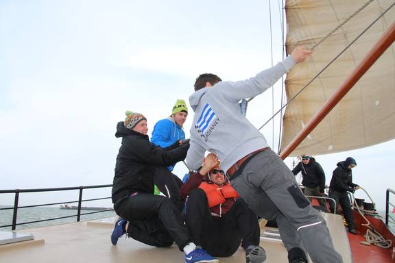 Guests helping to hoist a sail together on the Boekanier