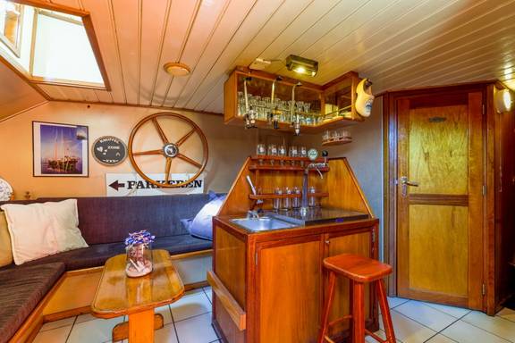 Seating area with a bar in the saloon of the Boekanier
