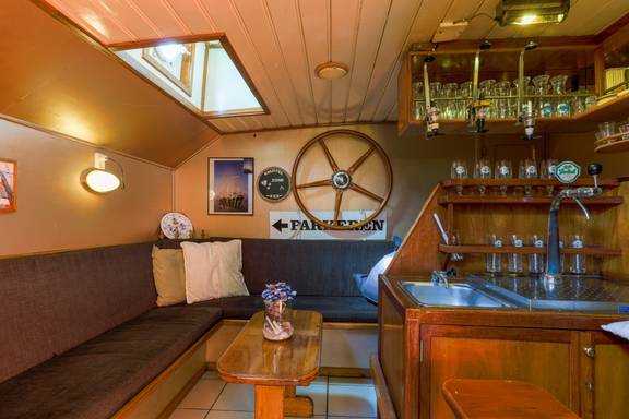 Wooden bar and seating area with nautical decorations on the Boekanier