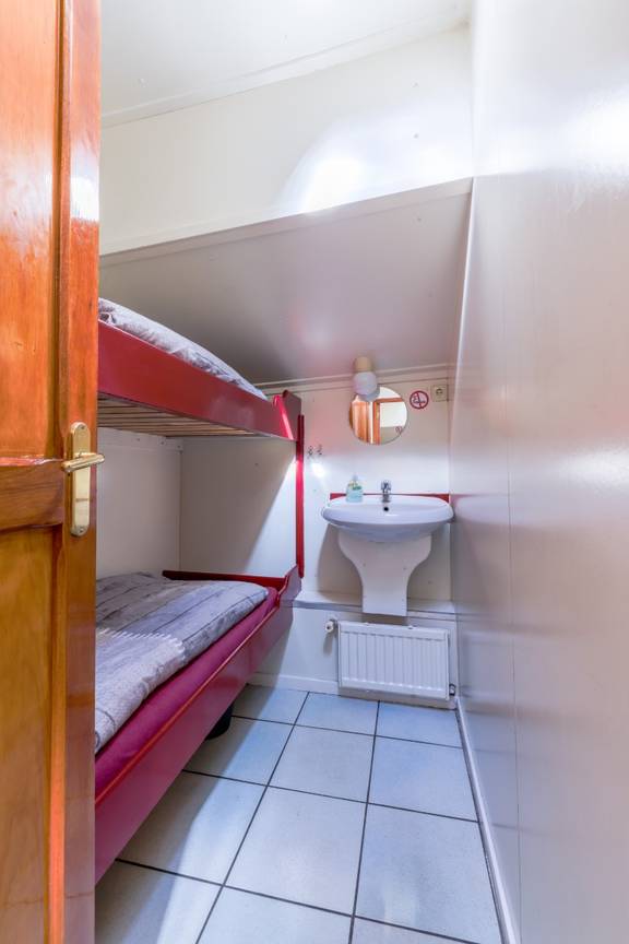 Twin-berth cabin with a bunk bed and washbasin on the Boekanier
