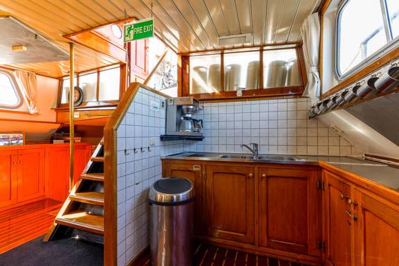 Galley with wooden cabinets beside the stairs on the Boekanier