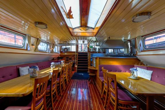Overview of the saloon of the Boekanier with a wooden floor and skylights