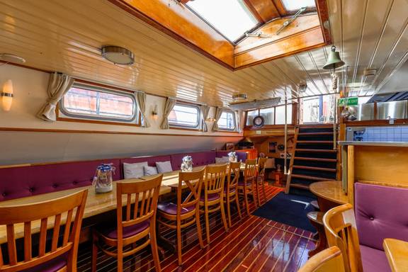 Long dining table beside the windows in the saloon of the Boekanier