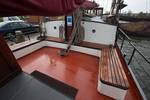 Wooden benches around the red deck seating area of the Boekanier