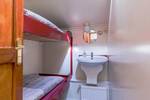 Twin-berth cabin with a bunk bed and washbasin on the Boekanier