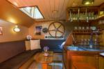 Wooden bar and seating area with nautical decorations on the Boekanier