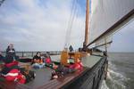 Guests on the foredeck of the Broedertrouw under sail